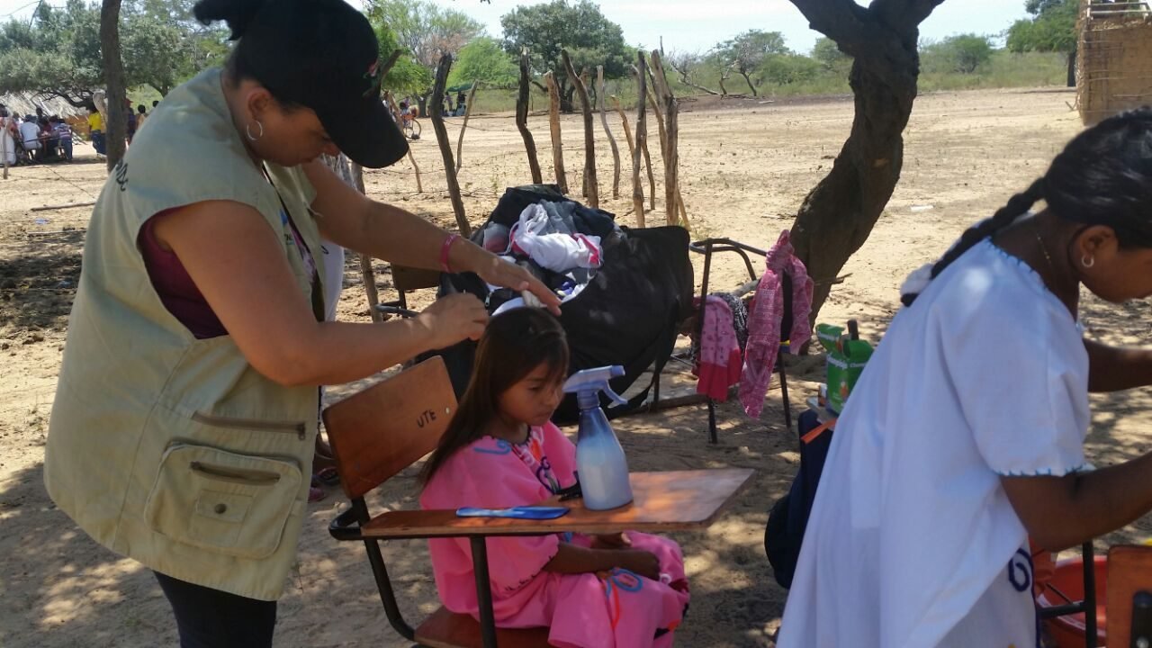 Agente comunitaria acompañando a una niña en el aula de la ranchería