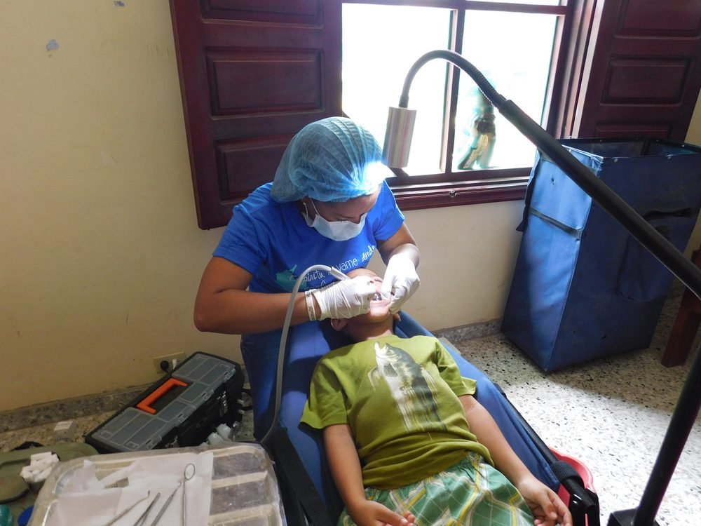 Odontóloga de la fundación atendiendo a un niño en una jornada de salud oral