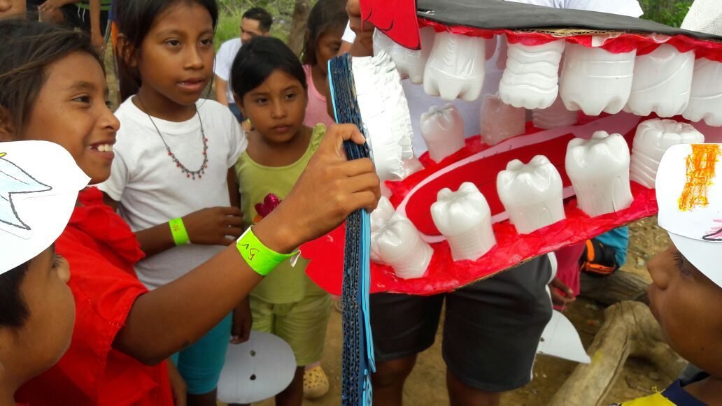 Niños aprendiendo higiene bucal con una dentadura gigante