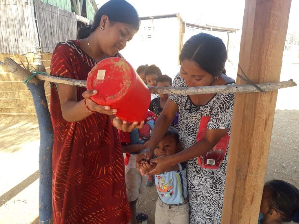 Mujer wayúu y niños participando en una actividad de la fundación